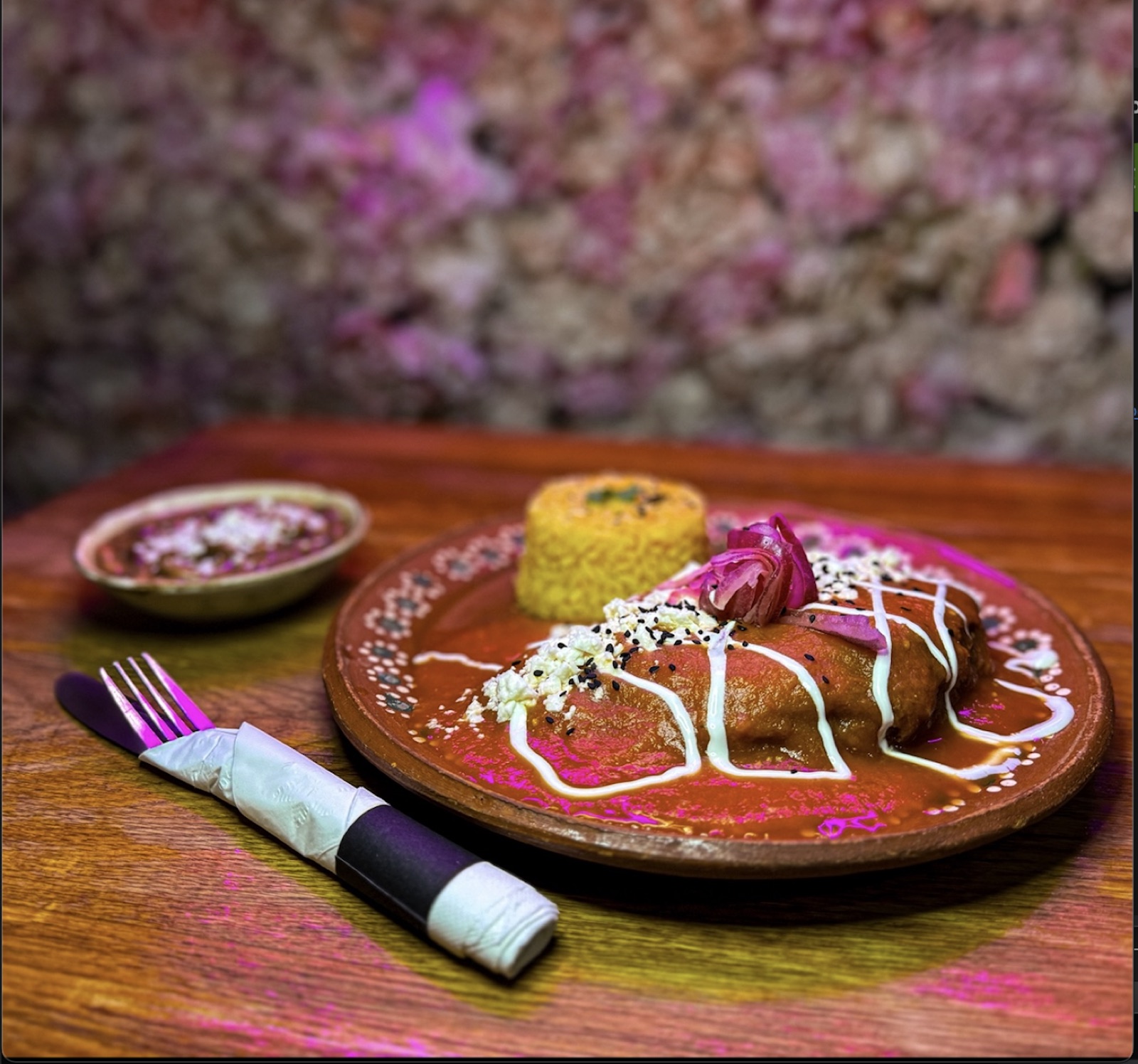 Chile Relleno stuffed poblano pepper in red salsa with crema, fresh cheese and rice